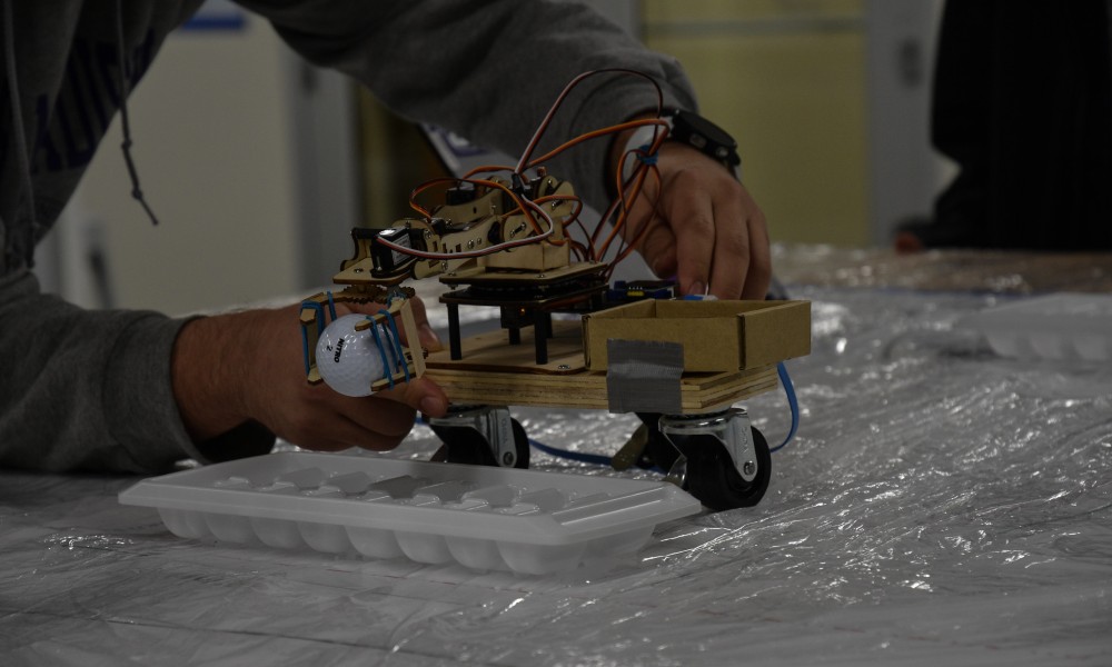 Close-up of a student wiring the robotic-arm prototype in ENGR 231